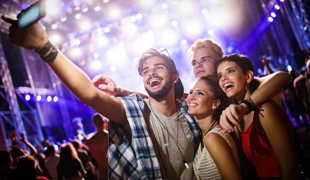 group of friends smiling and taking a selfie in a club during a party