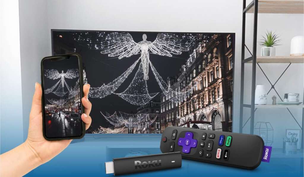 Roku stick and Roku remote. A smartphone casting an image of Christmas street to a smart TV.