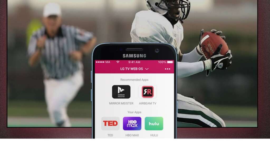 An LG TV with an image of an american football match on the screen. In the foreground, a Samsung smartphone with LG tV remote App App Launcher feature on the screen