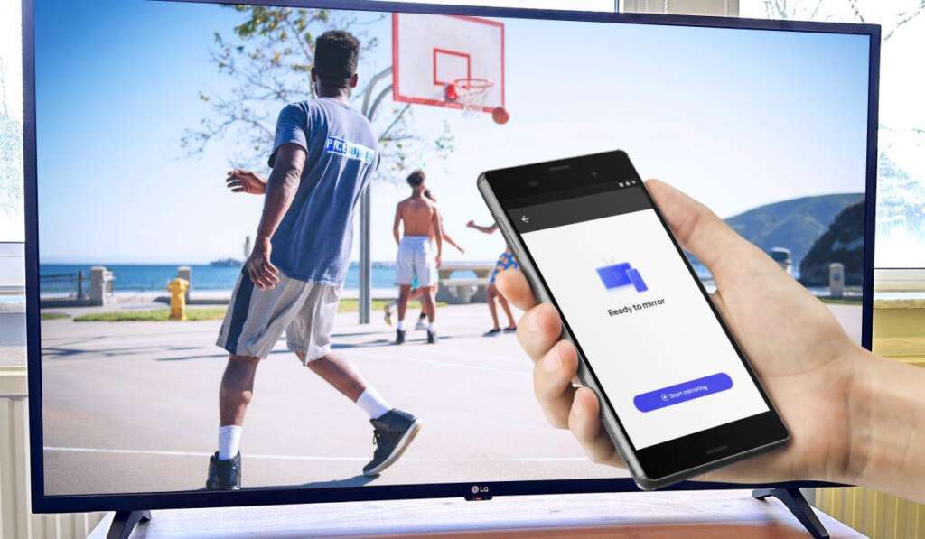 LG TV with an image of people playing street basketball. A hand holding an Android phone with the start mirroring screen of MirrorMeister