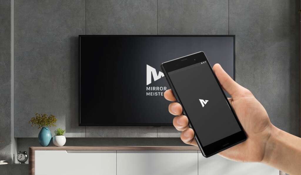 A hand holding an Android smartphone with MirrorMeister logo. A samsung tv with mirrormeister logo on the screen