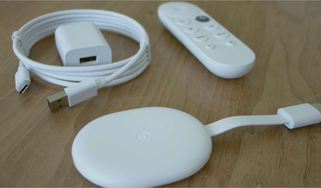 A Chromecast device, Chromecast remote, a charging cable and a charging plug unit.