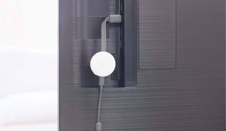 White streaming device plugged into the back of a Smart TV